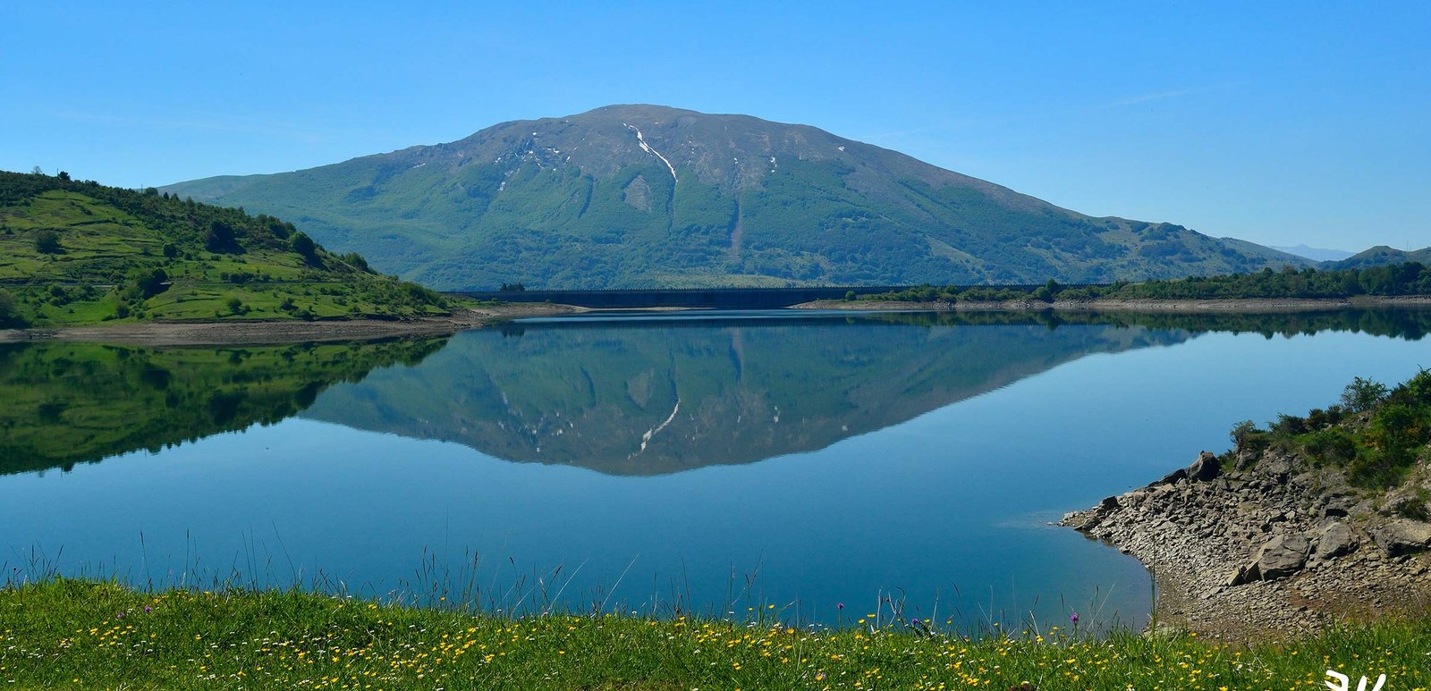 Vista panorámica de un embalse de montaña con el agua en calma
